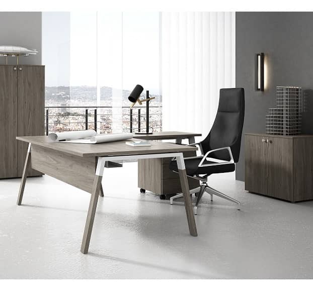 Mesa para despacho en forma de L con patas de madera natural, ala auxiliar, faldón y cajonera.